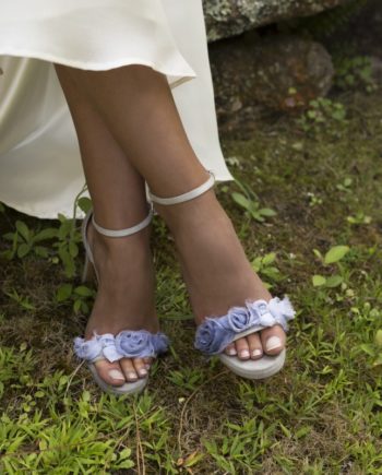 sandalias de novia adorno flores ante azul aguamarina cielo
